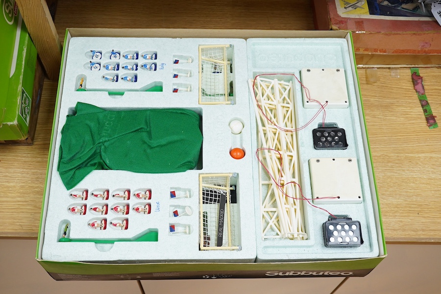 Two boxed Subbuteo table football sets; a European Edition, comprising of two teams, spectators and line side staff, pitch, etc. (some parts missing), and an International Edition, comprising of three teams, stadium ligh